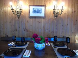 a dining room with a table with a vase of flowers at Hs4U Chalet sulle piste - Dolomiti - Madonna di Campiglio in Madonna di Campiglio