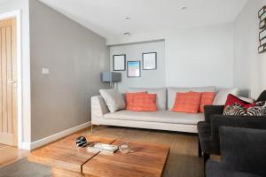 a living room with a couch and a table at The Norfolk Maisonette - Lovely 4BDR Mews in London