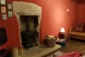 a living room with a stone fireplace in a room at Dove Cottage, Tideswell in Tideswell