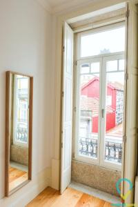 a room with two windows and a mirror at Simply Porto in Porto