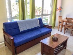ein blaues Sofa im Wohnzimmer mit einem Tisch in der Unterkunft Apartamento ARENA en Santa Cruz de la Palma in Santa Cruz de la Palma