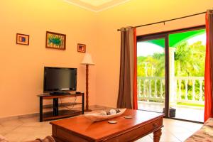 a living room with a tv and a table with a tv at Sunset Villa 3C by Splash Inn in Sandy Bay