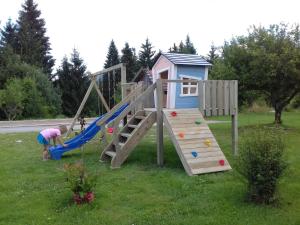 une aire de jeux avec un toboggan et une maison de jeux dans l'établissement Vila Snjeguljica, à Gorači