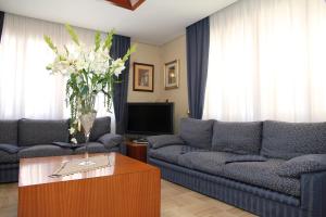 a living room with a couch and a vase of flowers at Hotel Da Remo in Roccaraso