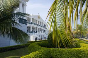 a white building with a palm tree in front of it at Taj Falaknuma Palace in Hyderabad