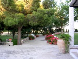 un parque con un banco, árboles y flores en El Mirador, en Quinto
