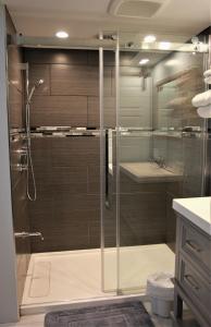 a bathroom with a shower with a glass door at Motel Le Refuge in Sherbrooke
