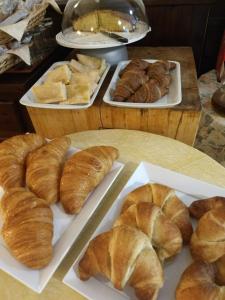 uma mesa coberta com pratos de croissants e outros produtos de pastelaria em Hotel Ristorante Sassi Rossi em Taceno