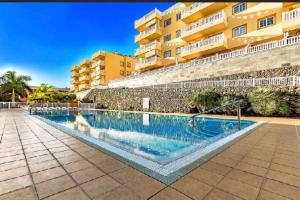 a swimming pool in front of a building at Apartamento Primavera I in Palm-Mar