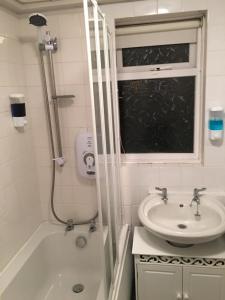 a bathroom with a shower and a sink and a tub at Travelling Stop in Swindon