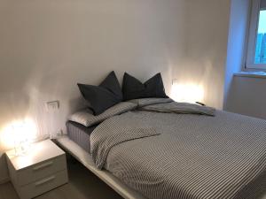 a bed with black pillows in a bedroom at Casa Bacca apartments in Trento