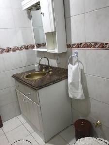 uma casa de banho com um lavatório e um espelho em Avenida Residence em Uruguaiana
