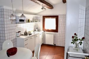 a small white kitchen with a table and a window at Corte delle Ancore in Venice