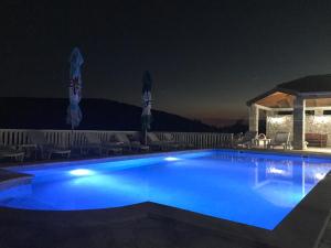 una piscina illuminata di notte di Apartments Vila Lazarevic a Tivat
