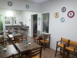 a restaurant with wooden tables and chairs and plates on the wall at Hotel Recanto das Perdizes in São Paulo
