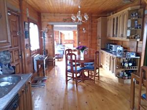 a kitchen with a table and chairs in a cabin at Casa - Chalet Madera Canadiense in Santa Cruz de Campezo