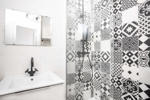 トゥールーズにあるAppartement 6 - Standing et Lumineux - Carmes, Toulouseのバスルーム(シンク、白黒のタイル張りのシャワー付)