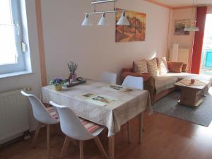 ein Wohnzimmer mit einem Tisch, Stühlen und einem Sofa in der Unterkunft Ferienwohnung Bernhard Ehlen in Saarbrücken