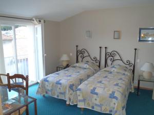 - une chambre avec 2 lits et une fenêtre dans l'établissement Grand Hôtel du Cours, à Sisteron