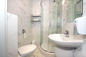 W łazience znajduje się umywalka, toaleta i prysznic. w obiekcie Willa Park Apartamenty w Olsztynie