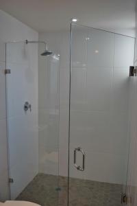 W łazience znajduje się prysznic ze szklanymi drzwiami. w obiekcie Hotel El Sausalito w mieście Ensenada