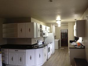 a kitchen with white cabinets and a white refrigerator at Glacier Guest Room - PRIVATE ROOM IN SHARED HOUSE REDUCED PRICE ON TOURS in Juneau