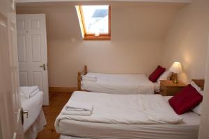 
a bedroom with a white bed and white walls at Ceol na Mara Holiday Homes - Cois Tra & Cor na dTonn in Enniscrone
