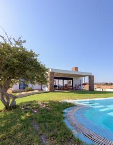 a villa with a swimming pool and a house at CRISTELIA SEAFRONT & POOL VILLA in Lakhania