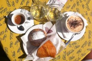 un tavolo con due piatti di pasticcini e una tazza di caffè di Soggiorno Paradiso a Napoli