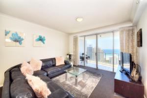 a living room with a leather couch and a large window at Deluxe Chevron Renaissance in Gold Coast