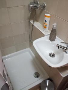 a white bathroom with a sink and a shower at Ruby room in Zagreb