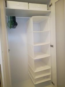 a walk in closet with white shelves at Ruby room in Zagreb