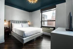 a bedroom with a bed and a tv and a window at The Hotel at New York City in New York