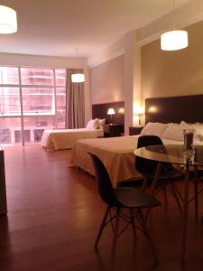 a hotel room with two beds and a table and chairs at 770Hotel in Mar del Plata
