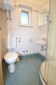 a bathroom with a toilet and a sink and a shower at Apartments Gaspar in Cres