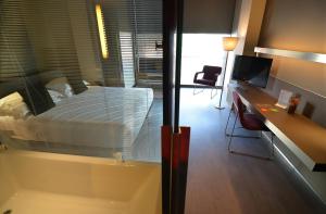 a bathroom with a tub and a desk with a computer at Hotel Soho in Barcelona