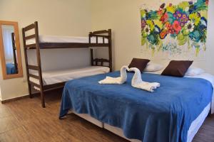two swans on a bed in a room with bunk beds at Guaiamu Suítes Ilhabela in Ilhabela