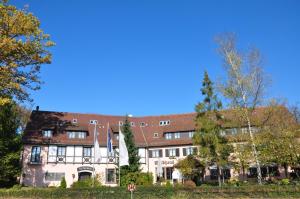 un gran edificio de ladrillo con techo rojo en relexa Waldhotel Schatten Stuttgart, en Stuttgart