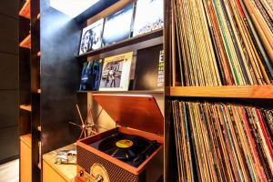 a record shelf with a record player and a stack of records at Kobe Motomachi Tokyu REI Hotel in Kobe