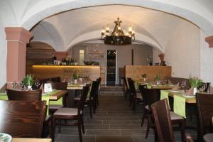 a dining room with tables and chairs and a chandelier at Weingut Gästehaus Derkum in Ürzig