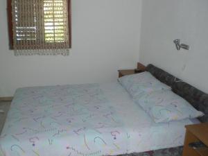 a bed in a bedroom with a bedspread withletters on it at VisForYou Apartments in Vis +16 photos