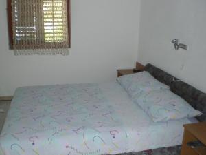 a bed in a bedroom with a bedspread withletters on it at VisForYou Apartments in Vis