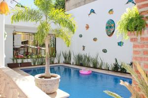 una piscina con una palmera en una casa en Villas Amalia Hotel, en Sayulita