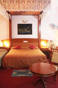 a bedroom with a bed and a table in it at Riverdale Hotel in Kandy