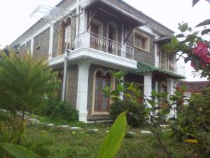 a house with a balcony on the side of it at Marie'z Villa in Tuktuk Siadong