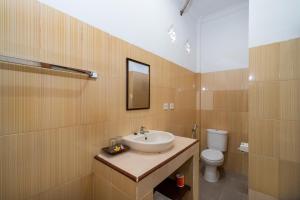 een badkamer met een wastafel en een toilet bij Krisna Home Stay in Nusa Lembongan