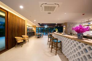 a bar in a restaurant with purple flowers at DeeProm Pattaya Hotel in Pattaya