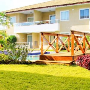 a house with a deck and a swimming pool at Guarajuba Verano in Guarajuba