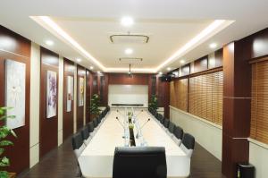 een vergaderzaal met een lange tafel en stoelen bij Graha SUMSEL in Jakarta