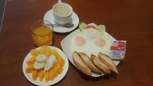 two plates of food with eggs and bread and a glass of orange juice at Villa Sayada in Luang Prabang +43 photos